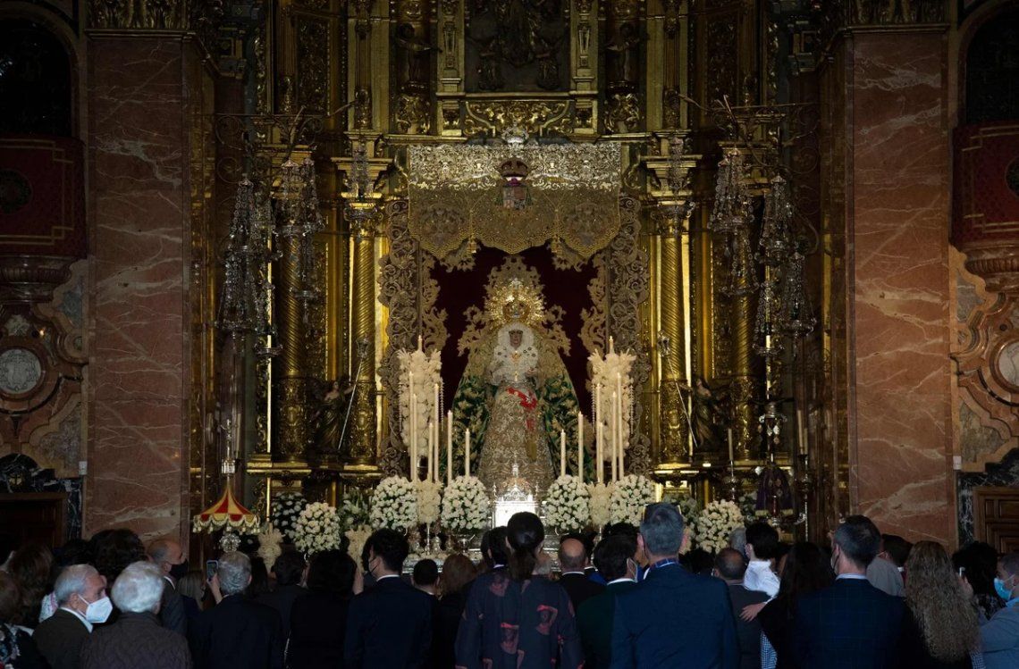Visitantes observan la figura de la Virgen Macarena en la basílica de la Macarena