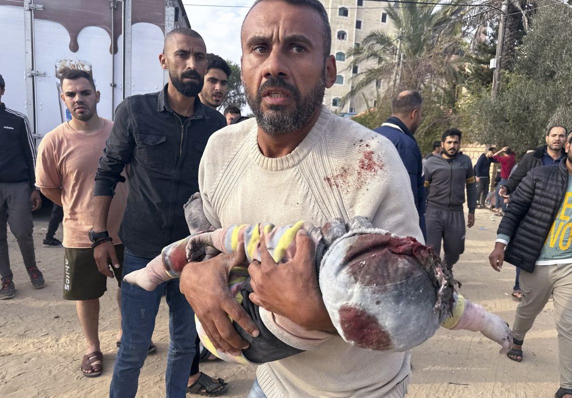 Un palestino evacua a un niño herido tras un ataque en Al Zawayda