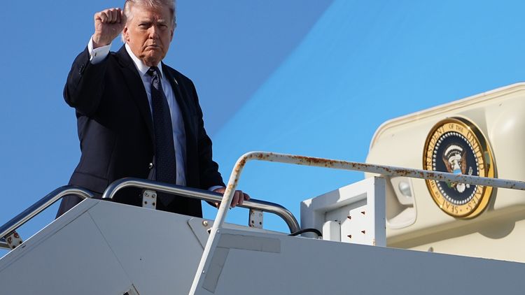Donald Trump saluda antes de abordar el avión presidencial.