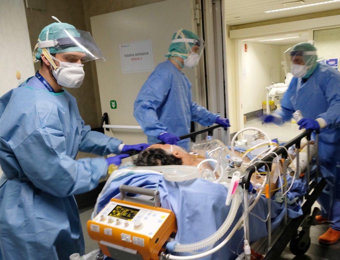 Tres profesionales de la salud trasladan a un paciente en un hospital de Brescia.