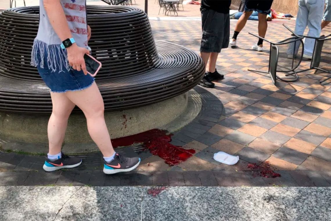 Restos de sangre de heridos y en el fondo cuerpos en el piso en un acto del Día de la Independencia en Illinois. 
