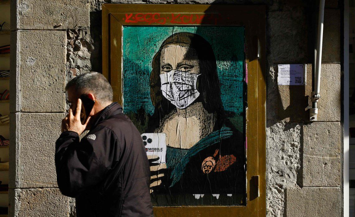 Un ciudadano español pasa delante de un cuadro con una Gioconda protegida con un barbijo.