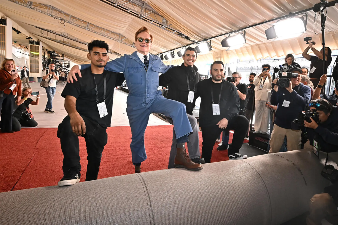 El presentador de los Oscar, Conan O'Brien, posa con el personal que estaba instalando la alfombra roja, el miércoles a la mañana