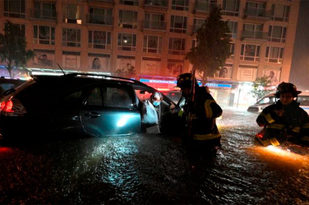 Bomberos de Nueva York rescatan a una mujer que quedó atrapada en su auto a causa de la repentina inundación de las calles.