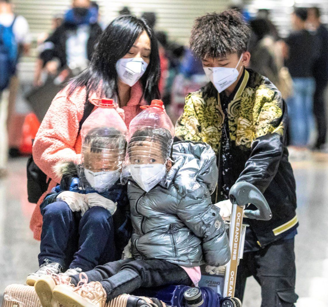 Dos niños con protecciones improvisadas en el aeropuerto de Cantón