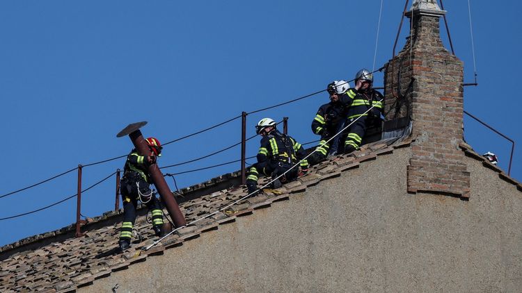 Unos cinco bomberos de la Santa Sede subieron al tejado del majestuoso edificio para colocar el humero.