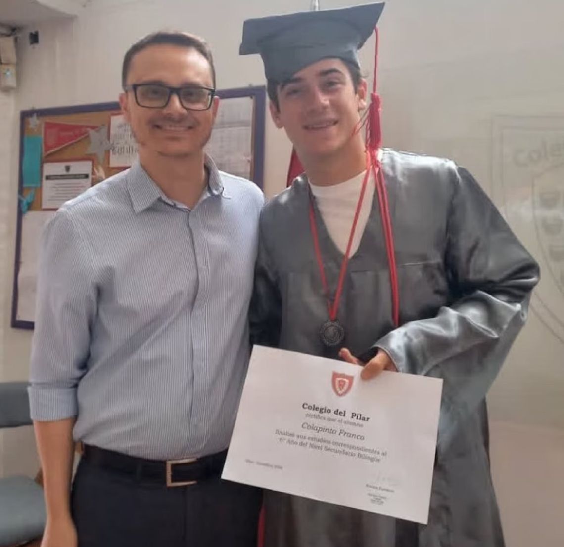 Con la toga y el diploma que acreditan que se recibió del secundario.