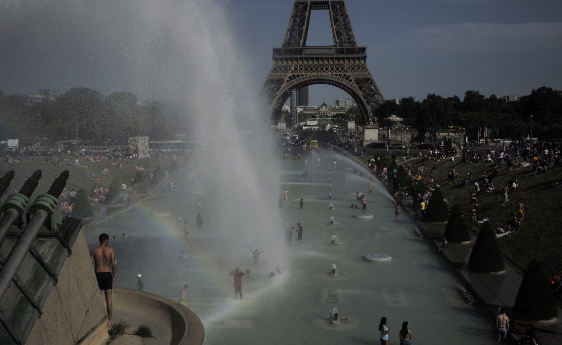 La gente busca un alivio en las fuentes de los jardines frente a la Torre Eiffel