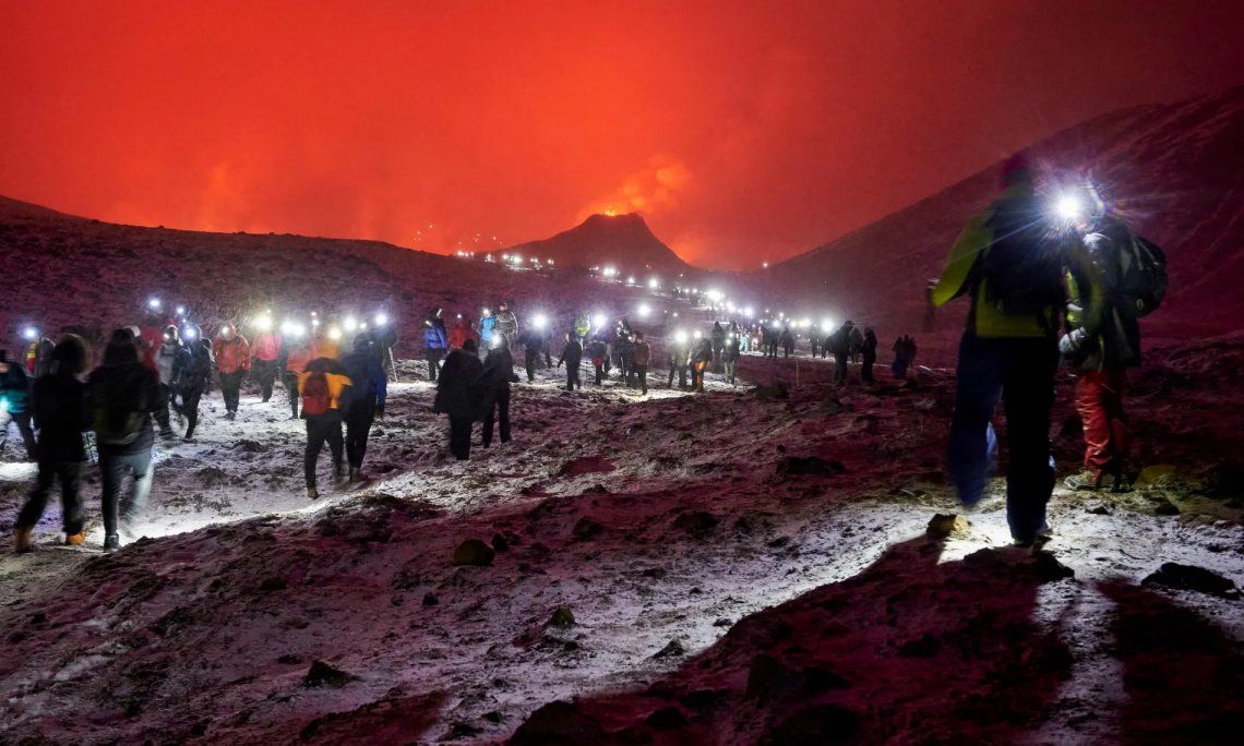 Excursionistas en el valle de Geldingadalur en Islandia van a ver la erupción de un volcán