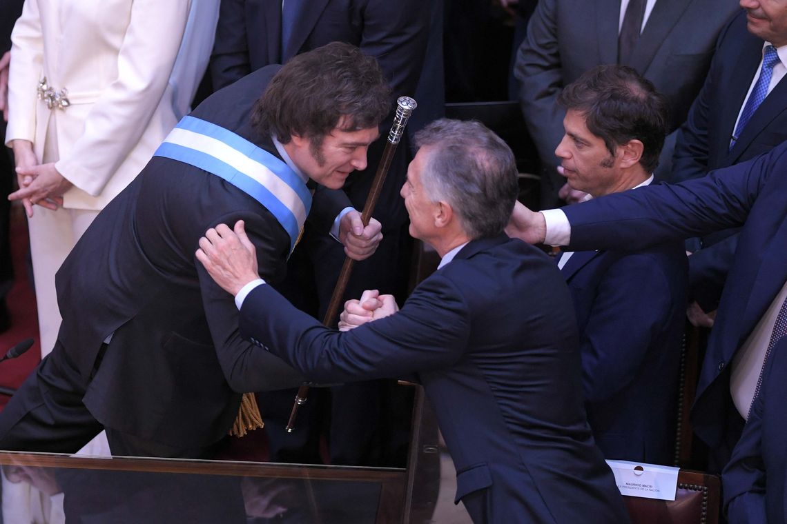 El flamante presidente saludó a Mauricio Macri después de prestar juramento en el Congreso.